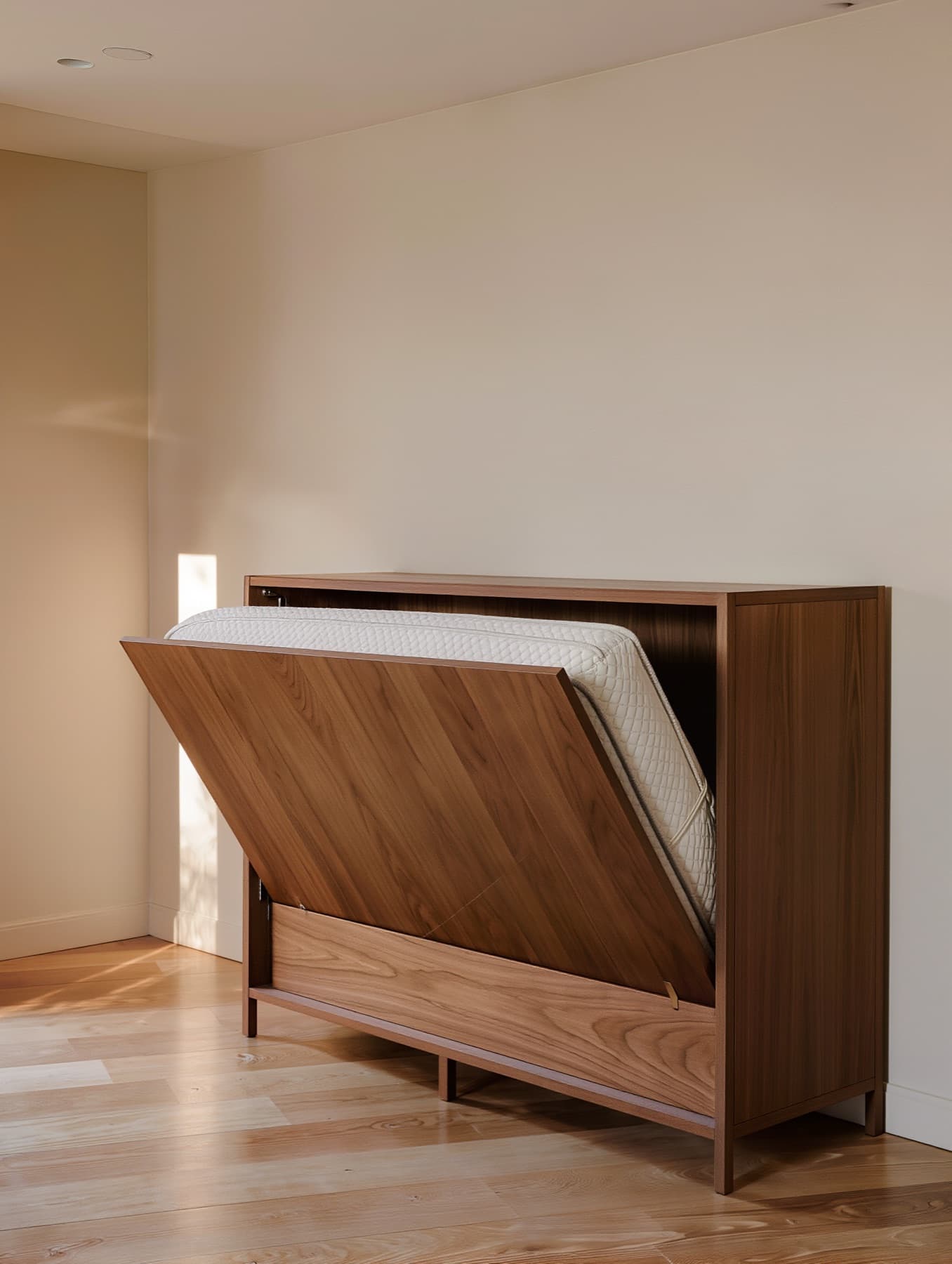Freestanding walnut cabinet bed on legs with its front panel folding down to reveal a folded mattress